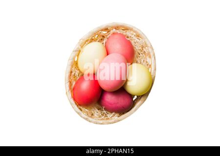 Korb mit bunten Ostereiern, isoliert auf weißem Hintergrund. Osterkorb gefüllt mit farbigen Eiern Top View Urlaubskonzept. Stockfoto