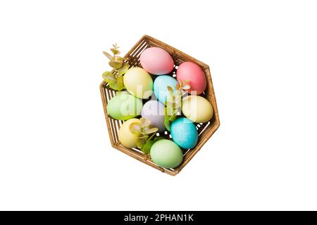 Korb mit bunten Ostereiern, isoliert auf weißem Hintergrund. Osterkorb gefüllt mit farbigen Eiern Top View Urlaubskonzept. Stockfoto