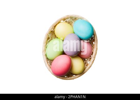 Korb mit bunten Ostereiern, isoliert auf weißem Hintergrund. Osterkorb gefüllt mit farbigen Eiern Top View Urlaubskonzept. Stockfoto