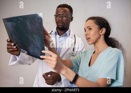 Zwei Ärzte überprüfen die Röntgenaufnahme des Patienten und besprechen die medizinische Chirurgie Behandlung Stockfoto