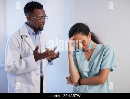 Senior Doctor spricht mit verärgertem Junior Doctor in Peeling, Unterstützung Mentoring Stockfoto
