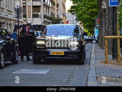 Paris, Frankreich - April 18. 2015 : Black Rolls Royce Phantom parkt in einer Straße im Viertel George V. Ein Angestellter eines Palastes öffnet dem Kus die Tür Stockfoto