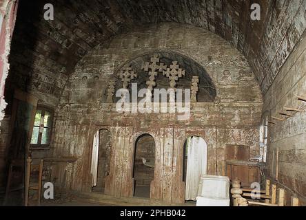 Alun, Hunedoara County, Rumänien, 2003. Das Innere der verlassenen hölzernen christlich-orthodoxen Kirche, ein historisches Denkmal aus dem 17. Jahrhundert. Blick auf die Ikonostase, mit handgeschnitzten Holzkreuzen oben. Stockfoto