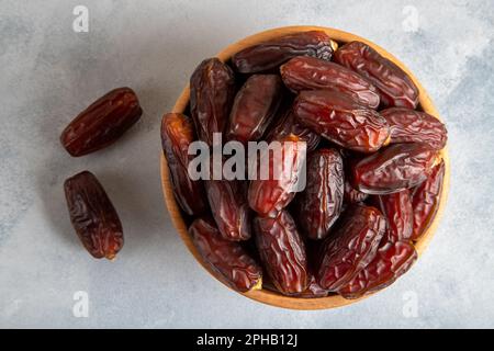 Datteln Sie Früchte in einer Holzschüssel auf hellem Hintergrund Stockfoto