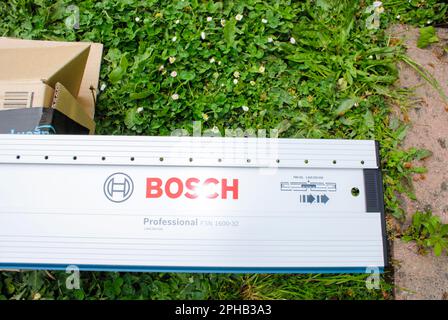 Paris, Frankreich - 4. april 29, 2022: Nahaufnahme der neuen Bosch Professional Spezial-perforierten Führungsschiene, die auf gree-Gras ausgepackt wird Stockfoto