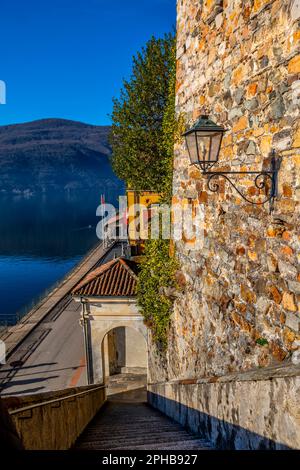 Treppe von der Kirche Santa Maria del Sasso gegen den blauen klaren Himmel und den Luganer See mit Berg an einem sonnigen Tag in Morcote, Ticino in der Schweiz. Stockfoto