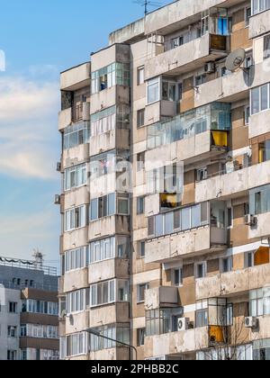 Abgenutztes Wohnhaus aus der kommunistischen Ära gegen blauen Himmel in Bukarest Rumänien. Hässliches traditionelles kommunistisches Wohnensemble Stockfoto