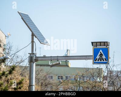 Zebra-Verkehrszeichen oder Fußgängerverkehrszeichen, angetrieben durch ein Solarpaneel. Stockfoto