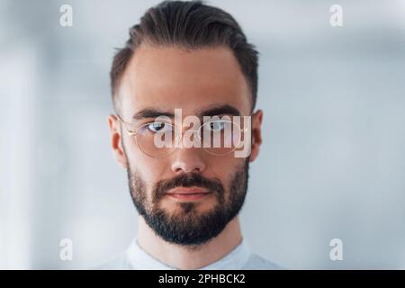 Porträt eines jungen gutaussehenden Mannes in formeller Kleidung im Büro am Tag Stockfoto