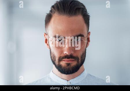 Porträt eines jungen gutaussehenden Mannes in formeller Kleidung im Büro am Tag Stockfoto