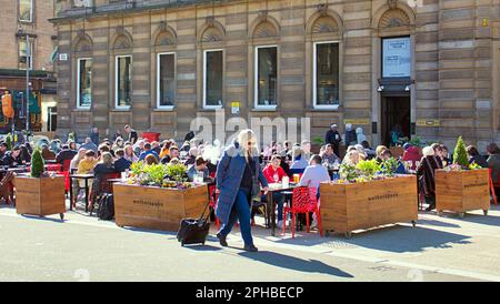 Glasgow, Schottland, Vereinigtes Königreich, 27. März 2023. UK Weather: Sonnig im Stadtzentrum am Nachmittag gingen die Einheimischen auf die Straße. Spaß auf dem george Square, wo Witherspoons zur Permament außerhalb der Tische für ihren Pub „The Counting House“ freigelassen wurden, um ihm ein mehr Kontinrntal Feeling zu geben. Credit Gerard Ferry/Alamy Live News Stockfoto