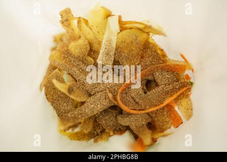 Ein Haufen organischer Lebensmittelabfälle, der mit bokashi-Kleie in einem Komposter bedeckt ist. Biologisch abbaubare Müllkompostierung im Abfalleimer. Stockfoto