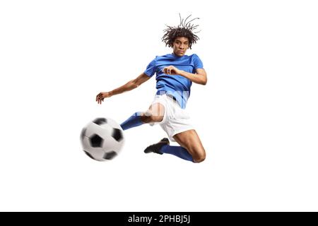 Ein afroamerikanischer Fußballspieler springt und tritt einen Ball isoliert auf weißem Hintergrund Stockfoto