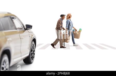 Auto fährt auf einen Fußgänger zu und eine Frau mit einem älteren Mann überquert die Straße und trägt Einkaufstaschen isoliert auf weißem Hintergrund Stockfoto
