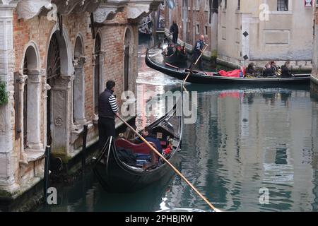 Gondoliere rudern ihre eigenen Gondeln entlang der Kanäle von venedig Gondoliere rudern ihre eigenen Gondeln entlang der Kanäle von venedig Stockfoto