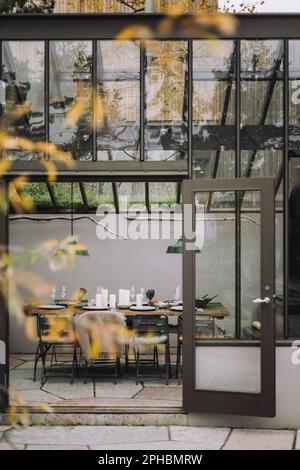 Tischaufstellung im Speisesaal für Dinnerparty im Hinterhof Stockfoto