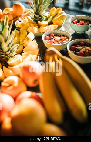 Auswahl an frischem Obst und Frühstück auf dem Tisch im Retreat Center Stockfoto
