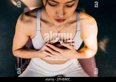 Aus dem Blickwinkel einer Frau, die mit den Händen auf der Brust trainiert Stockfoto