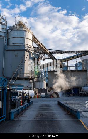 Das Morgenlicht beleuchtet die industrielle Aktivität im Ocean Concrete Plant auf Granville Island, Vancouver, BC Stockfoto