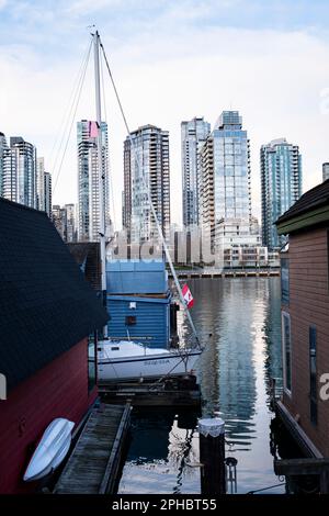 Hausboote und die Skyline von Vancouver sehen Sie am späten Nachmittag an einem Frühlingstag vom Ufer und den Docks von Granville Island aus. Stockfoto