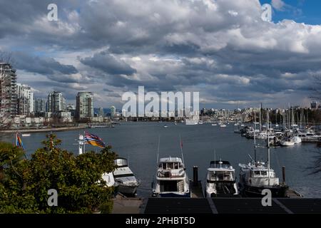 Regenwolken und leuchtend blauer Himmel über Wolkenkratzern und Booten, die in False Creek bei Granville Island in Vancouver, British Columbia, vor Anker liegen Stockfoto