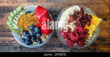 Acai Bowls Top View Banner Panorama von gesunden Speisen Frühstück Smoothie Schale im Restaurant. Zwei Obstbecher gefüllt mit Spirulina, Kiwi, Goji-Beeren Stockfoto