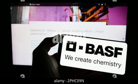 Person, die ein Smartphone mit dem Logo des deutschen Chemieunternehmens BASF SE auf dem Bildschirm vor der Website hält. Konzentrieren Sie sich auf das Display des Telefons. Stockfoto