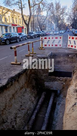 Eingezäunte Grube mit Rohrleitungen in einer Stadtstraße. Reparatur des Unfalls der Hauptleitung. Odessa Ukraine Stockfoto