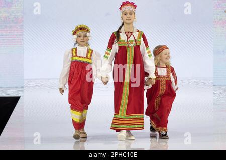 Moskau, Russland. 26. März 2023. Models präsentieren traditionelle russische Nationalkostüme auf einem Laufsteg als Teil der Show „Edges of the World“ beim Kids Fashion Week Kindermodefestival im Central Children's Store auf Lubjanka in Moskau, Russland Stockfoto