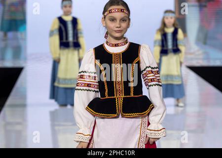 Moskau, Russland. 26. März 2023. Models präsentieren traditionelle russische Nationalkostüme auf einem Laufsteg als Teil der Show „Edges of the World“ beim Kids Fashion Week Kindermodefestival im Central Children's Store auf Lubjanka in Moskau, Russland Stockfoto