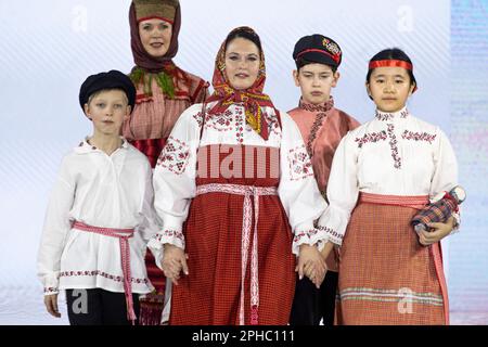 Moskau, Russland. 26. März 2023. Models präsentieren traditionelle russische Nationalkostüme auf einem Laufsteg als Teil der Show „Edges of the World“ beim Kids Fashion Week Kindermodefestival im Central Children's Store auf Lubjanka in Moskau, Russland Stockfoto