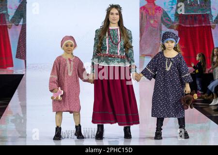 Moskau, Russland. 26. März 2023. Models präsentieren Cosack Nationalkostüme (Kuban Region) auf einem Laufsteg als Teil der Show „Edges of the World“ beim Kids Fashion Week Kindermodefestival im Central Children's Store auf Lubjanka in Moskau, Russland Stockfoto