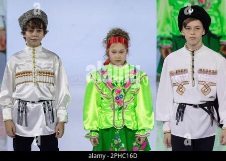 Moskau, Russland. 26. März 2023. Models präsentieren russische Nationalkostüme auf einem Laufsteg als Teil der Show „Edges of the World“ beim Kids Fashion Week Kindermodefestival im Central Children's Store auf Lubjanka in Moskau, Russland Stockfoto