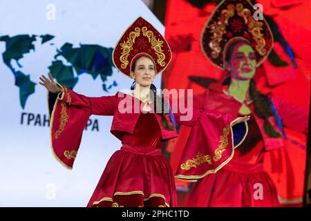 Moskau, Russland. 26. März 2023. Ein Modell präsentiert traditionelle russische Nationalkostüme auf einem Laufsteg als Teil der Show „Edges of the World“ beim Kids Fashion Week Kindermodefestival im Central Children's Store auf Lubjanka in Moskau, Russland Stockfoto