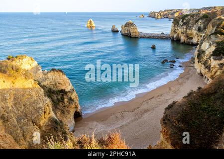 Der Blick aus einem hohen Winkel auf die Klippe verleiht dem Strand Praia do Pinhao, auch bekannt als Baía dos Segredos, ein Gefühl der Höhe, der in der goldenen Sonne gebadet wird. Stockfoto
