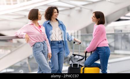 Drei Schöne Frauen, Die Sich Unterhalten, Während Sie Auf Den Flug Warten Stockfoto