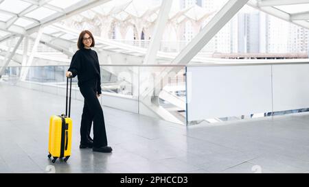 Wunderschöne Junge Frau Mit Koffer Steht In Der Flughafenhalle Stockfoto