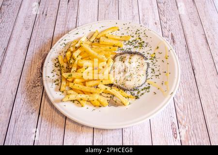 Gebratener Fisch und Pommes Frites werden seit vielen Jahren getrennt in verschiedenen Gerichten angeboten. Die Kartoffel erreichte den europäischen Kontinent erst im 16. Jahrhundert Stockfoto