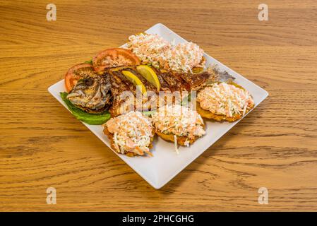 Gebratener Fisch begleitet gewöhnlich ganze Fische, in Stücken oder filetiert mit Pataconen und Kokosreis, was eine sehr beliebte Mahlzeit in Strandrestaurants ist Stockfoto