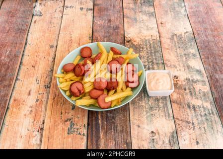 Salchipapa ist ein Fast Food, das aus gebratenen Wurstscheiben und Pommes frites besteht und in Lateinamerika beliebt ist Stockfoto