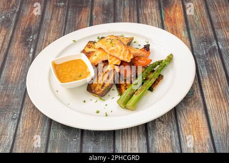 Gegrillter Lachs mit sautiertem Gemüse. Ein ideales Gericht, um Gewicht zu verlieren Stockfoto