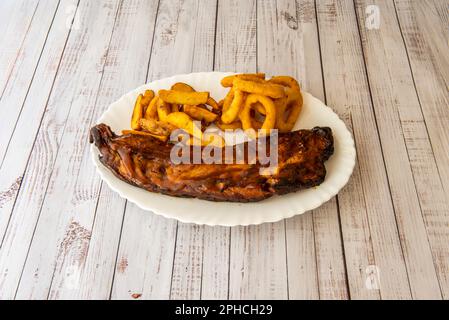 Grillrippchen sind ein Klassiker der amerikanischen Gastronomie. Köstliche Schweinerippchen, gebadet in einer süßen und sauren BBQ-Sauce Stockfoto