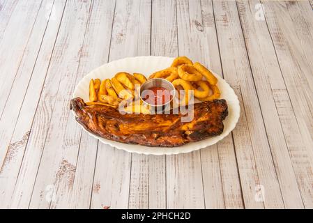 Grillrippchen sind ein Klassiker der amerikanischen Gastronomie. Köstliche Schweinerippchen, gebadet in einer süßen und sauren BBQ-Sauce Stockfoto