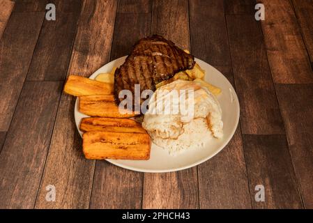 Bistec a lo pobre ist ein Gericht der peruanischen und chilenischen Gastronomie. In beiden Ländern gibt es gegrilltes Rindfleisch, Eier und Kartoffelrösti Stockfoto