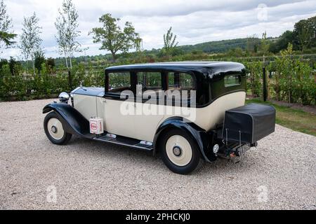 1932 Rolls-Royce 20/25 auf einer Schotterstraße mit Bäumen und Gärten in ländlicher Umgebung Stockfoto