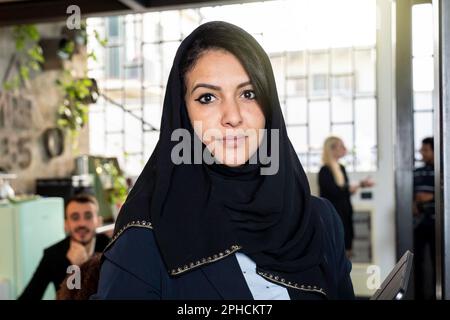 nordafrikanische Geschäftsfrau trägt einen typisch islamischen Hijab-Schleier und arbeitet in einem modernen Büro mit dem multiethnischen Team - Konzept der Führung und Stockfoto