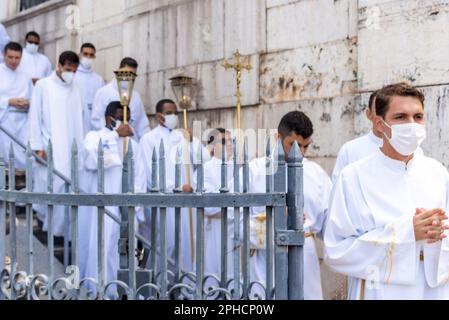 Salvador, Bahia, Brasilien - 08. Dezember 2022: Priester und Seminare steigen die Stufen der Kirche hinab Hunderte von Menschen beten während einer Open-Air-Messe Stockfoto