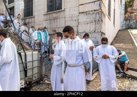 Salvador, Bahia, Brasilien - 08. Dezember 2022: Priester und Seminare steigen die Stufen der Kirche hinab Hunderte von Menschen beten während einer Open-Air-Messe Stockfoto