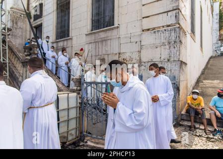 Salvador, Bahia, Brasilien - 08. Dezember 2022: Priester und Seminare steigen die Stufen der Kirche hinab Hunderte von Menschen beten während einer Open-Air-Messe Stockfoto