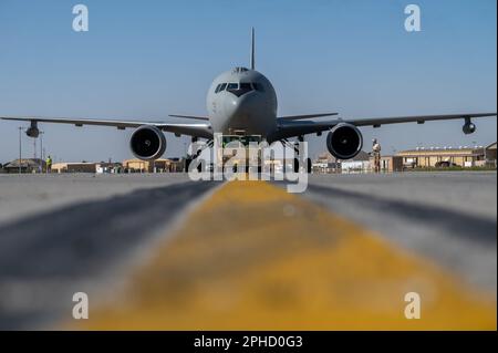 Italienische und amerikanische Streitkräfte schleppen einen italienischen KC-767 zu einem angrenzenden Abschnitt der Fluglinie, um den Start am Ali Al Salem Air Base, Kuwait, 18. März 2023 vorzubereiten. Die italienische Task Force Air-Kuwait arbeitete mit dem 386. Air Expeditionary Wing zusammen, um verschiedene agile Beschäftigungskonzepte für den Kampf zu validieren. Joint Ventures wie dieses verstärken die Unterstützung der italienischen Streitkräfte für die USA Verantwortungsbereich des Zentralkommandos. (USA Air Force Foto von Senior Airman Devan Halstead) Stockfoto